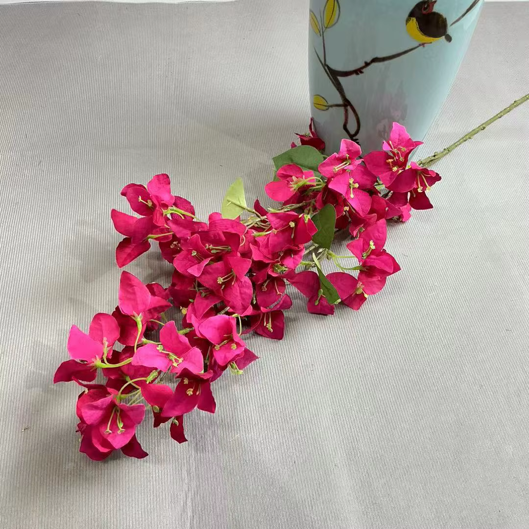 Une branche de fleur de bougainville artificielle, deux fourchettes, tige d'arbre de bougainvillea