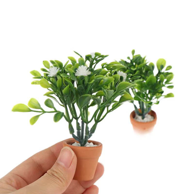 Miniature de fleur blanche et de plante verte en pot