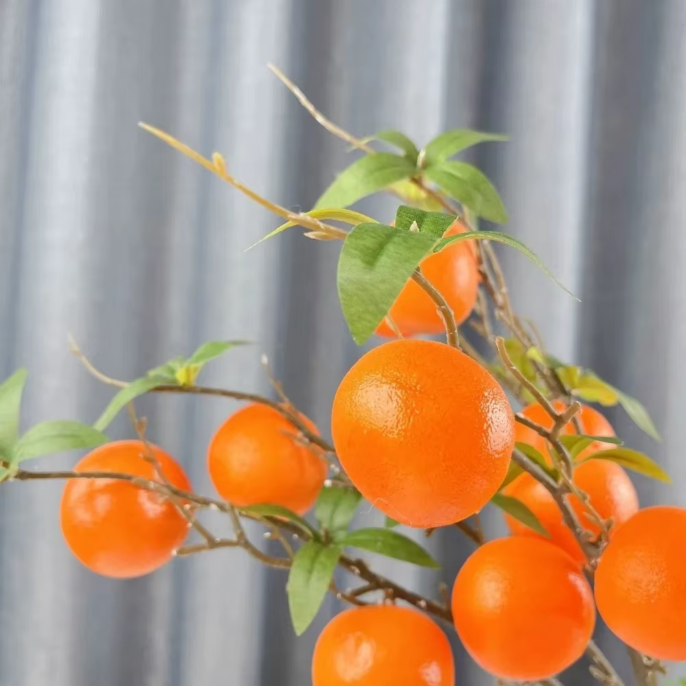 Branche d'orange artificielle avec feuilles vertes réalistes